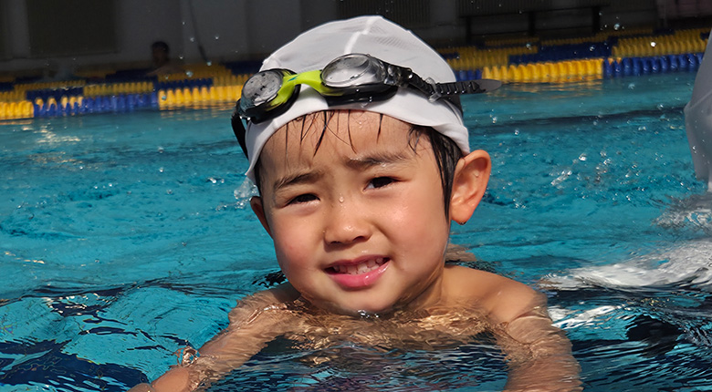 男の子がプールに浮かんでいる